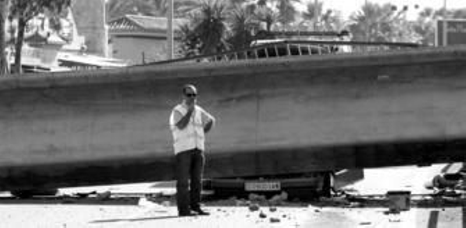 La impresionante estructura derribada, en cuyos bajos se observa un coche aplastado.