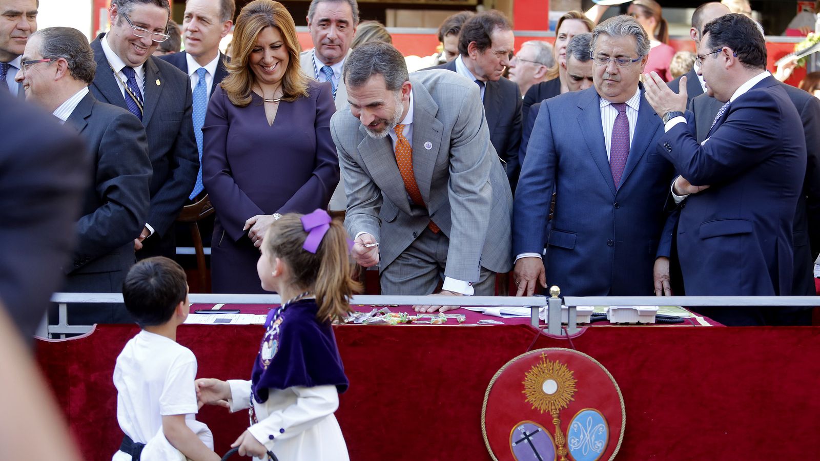 El Rey Felipe VI recoge una estampita a una monaguilla de la Hermandad del Beso de Judas.
