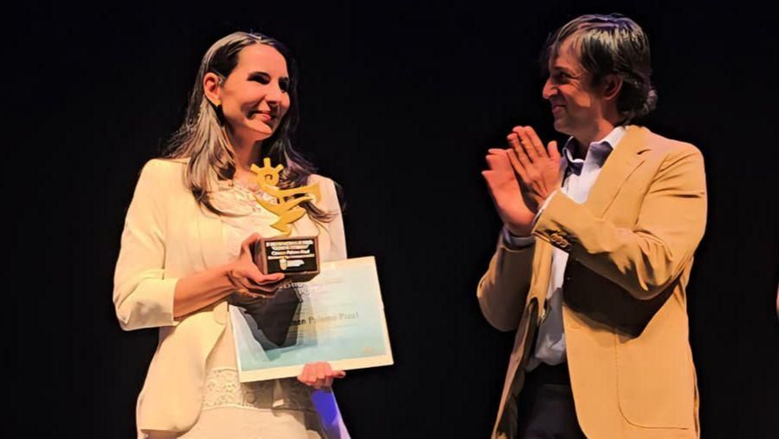 Carme Palomo recoge el premio de manos del alcalde del municipio.