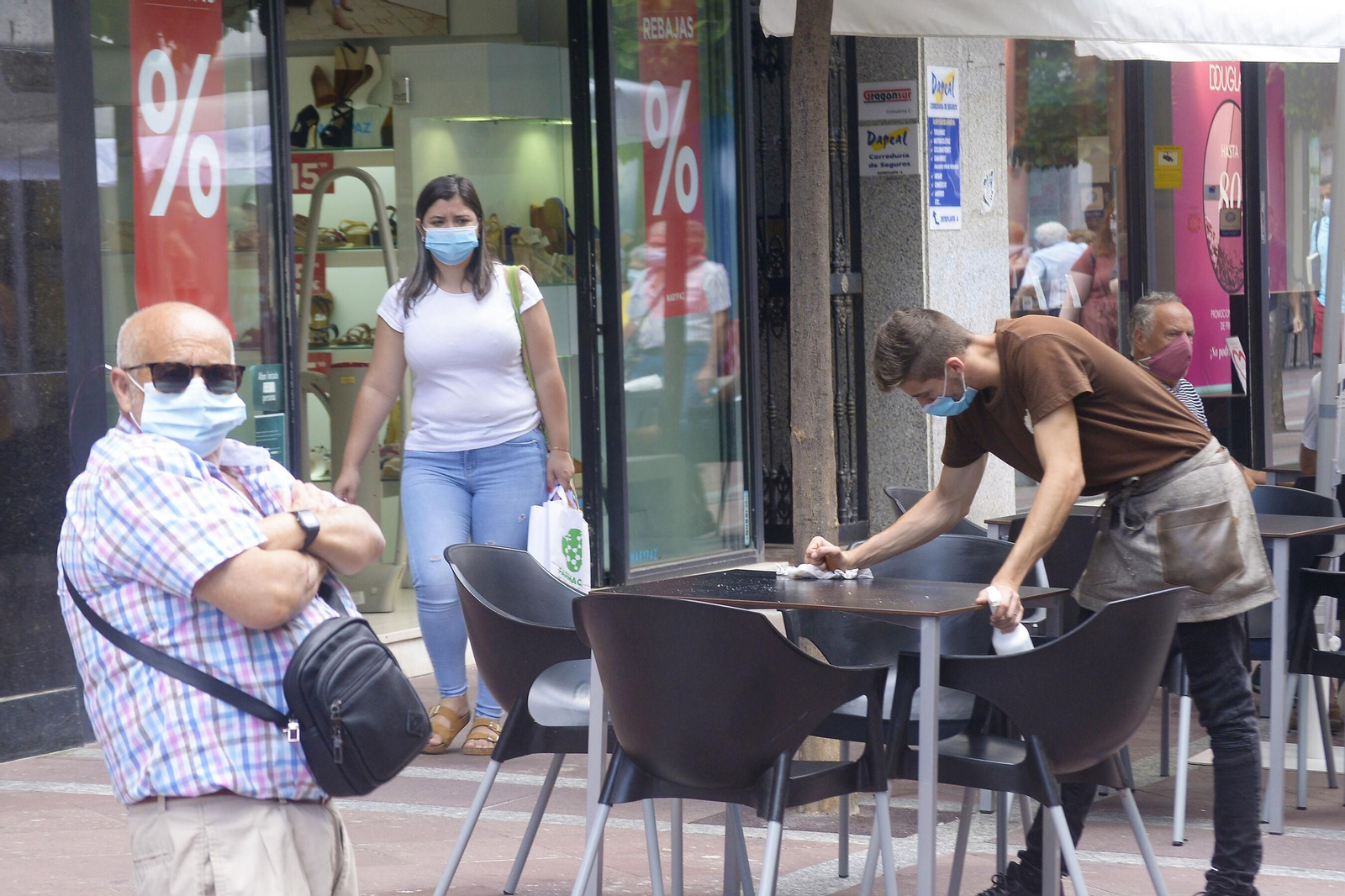 Un camarero limpia una mesa de un bar de Algeciras