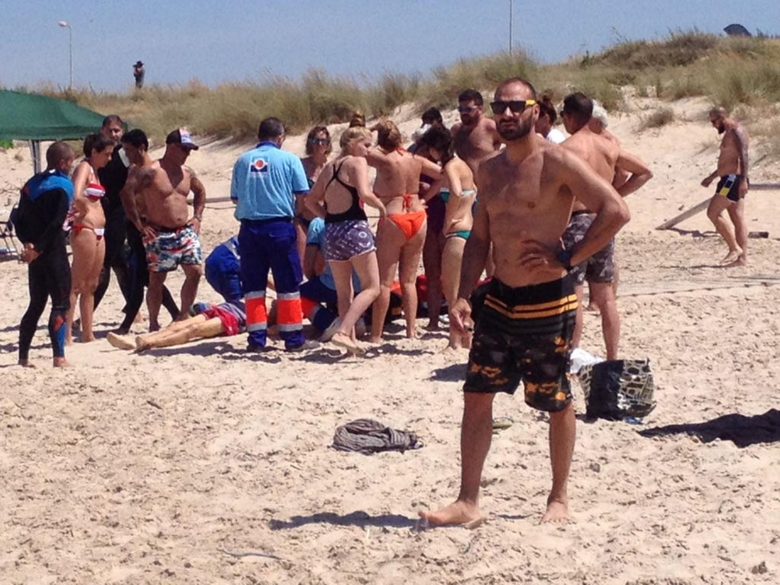 El fallecido, al fondo, junto a miembros de los servicios sanitarios y bañistas que se acercaron al lugar.