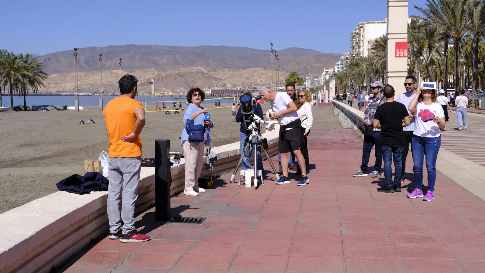 Almería observa el eclipse solar desde el Paseo Marítimo, en imágenes