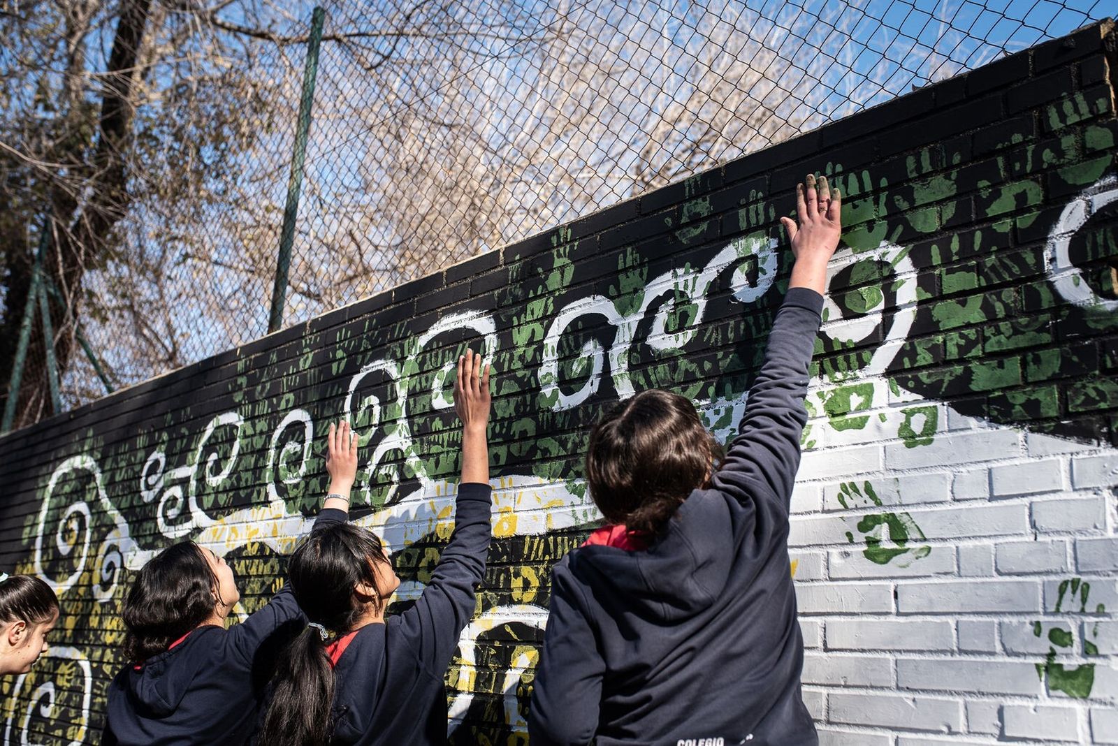 Alumnos de La Hispanidad ponen la palma de la mano en el mural.