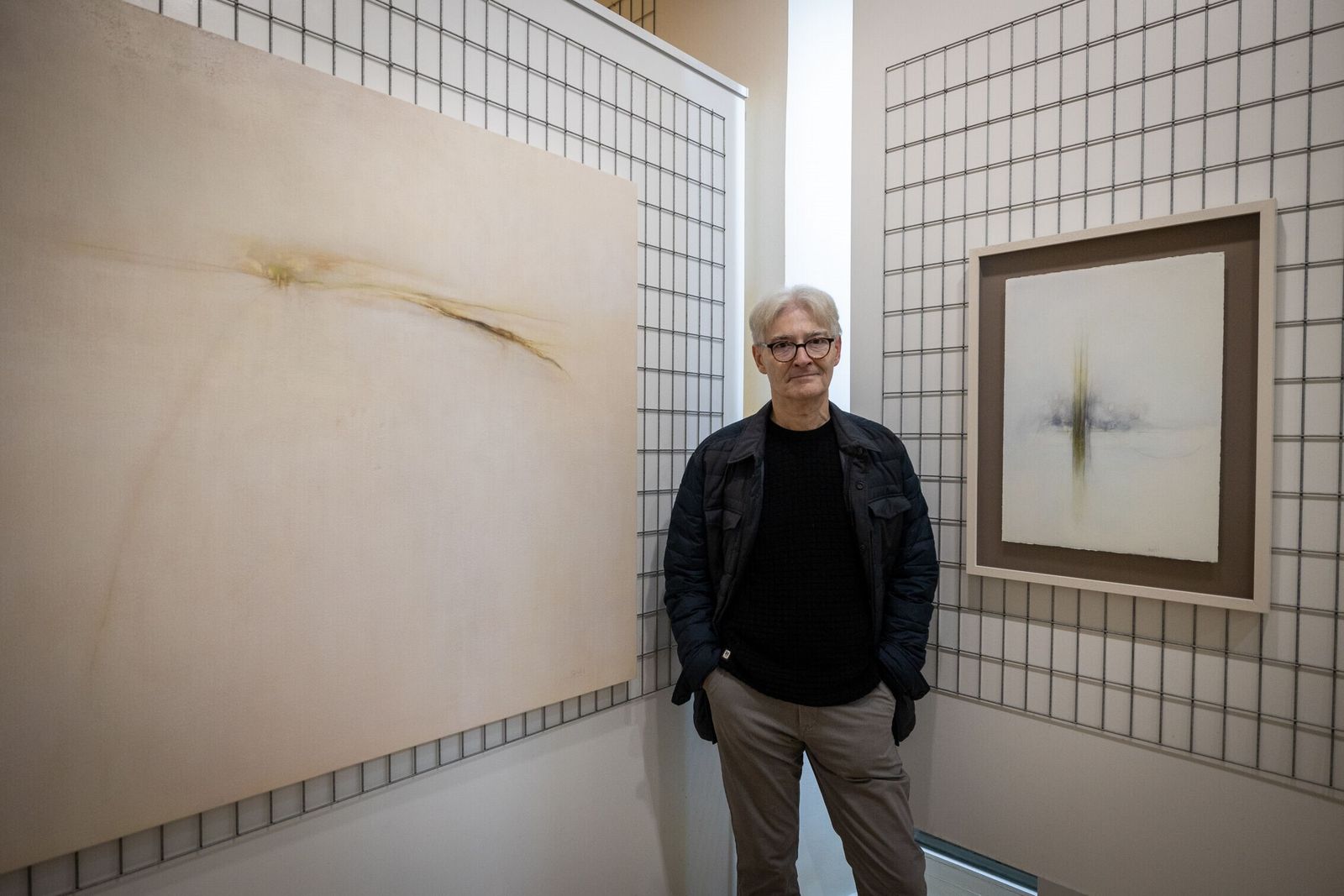 El pintor portuense Juan Carlos Busutil ante dos obras de su exposición en Benot.