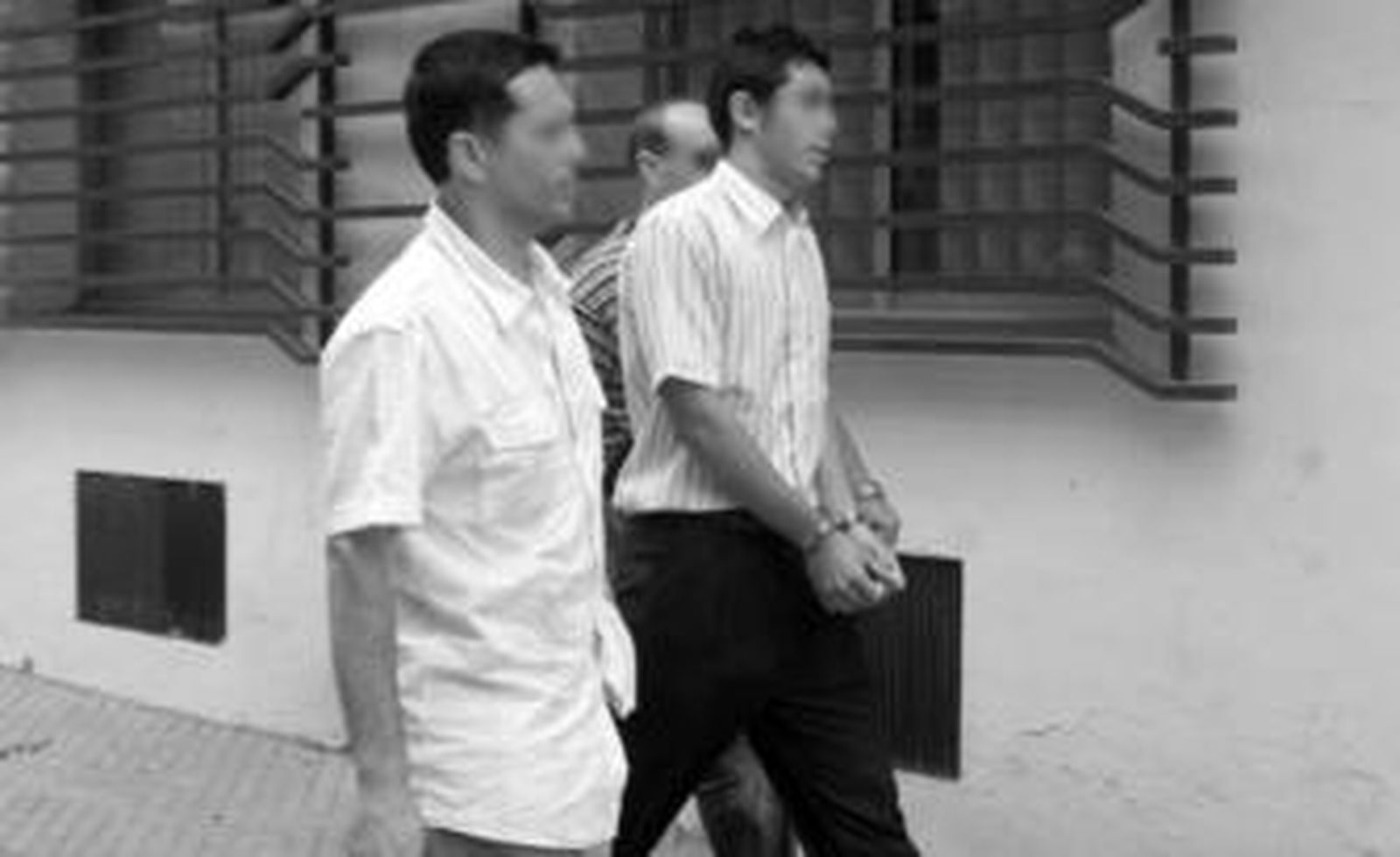 Uno de los acusados -en el centro-antes de entrar al juicio, ayer.