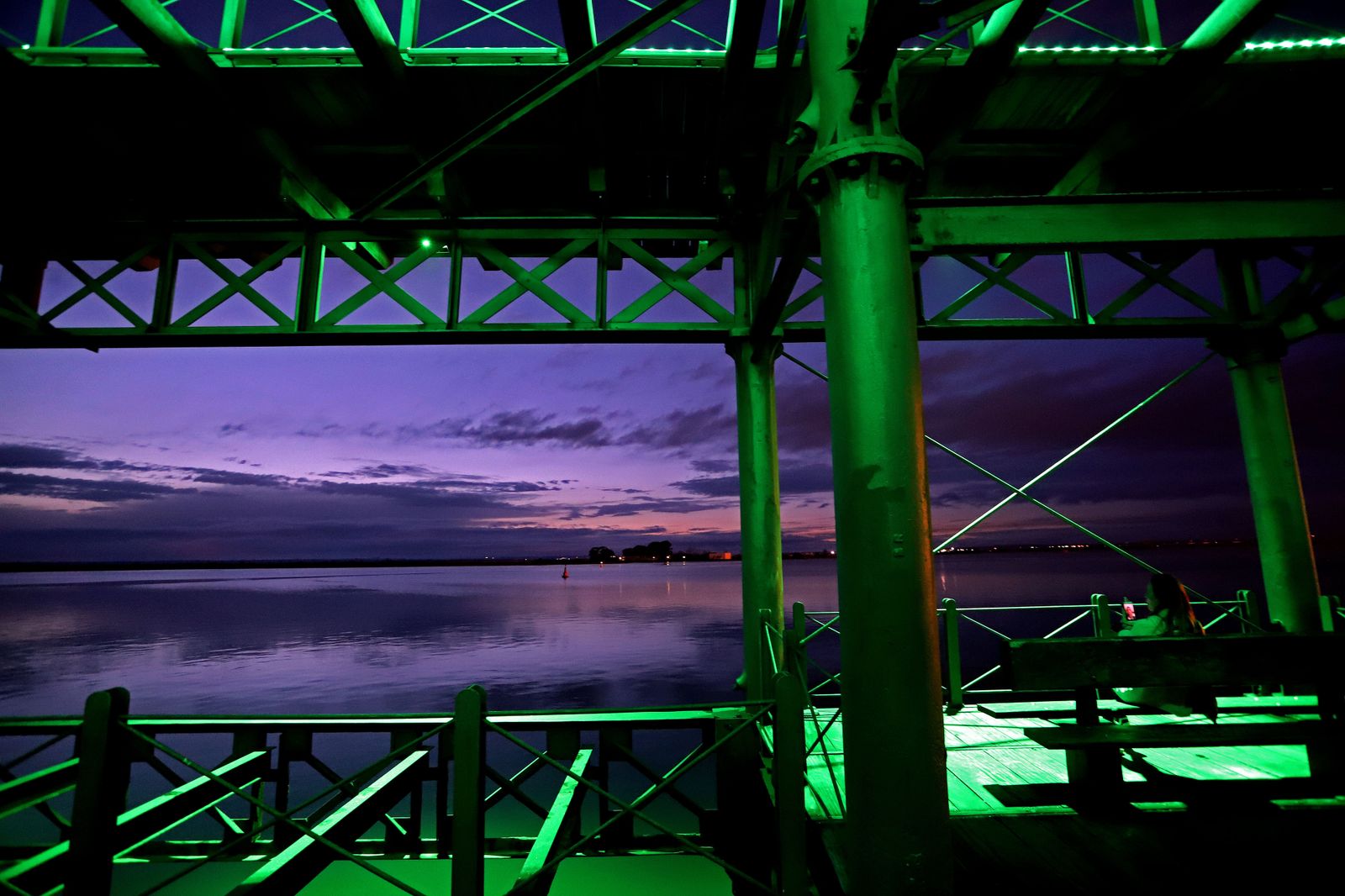 El muelle de la Riotinto se ilumina de verde en el día mundial contra el cancer