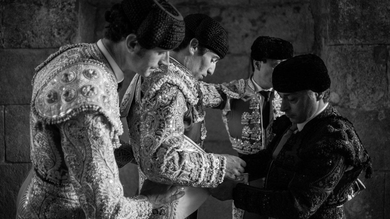 Los banderilleros ayudan al torero a liarse el capote de paseo.