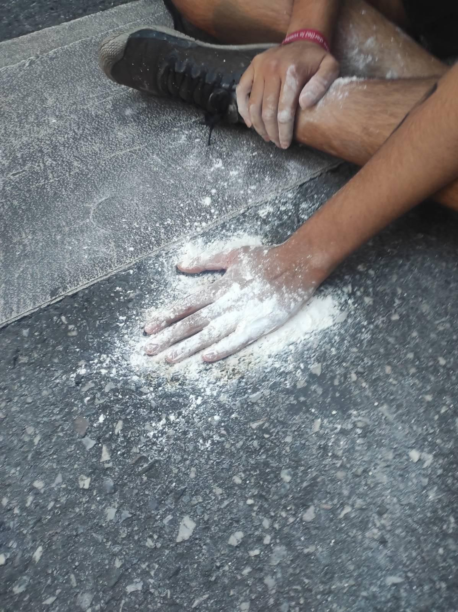 Uno de los activistas tras pegar su mano en el asfalto