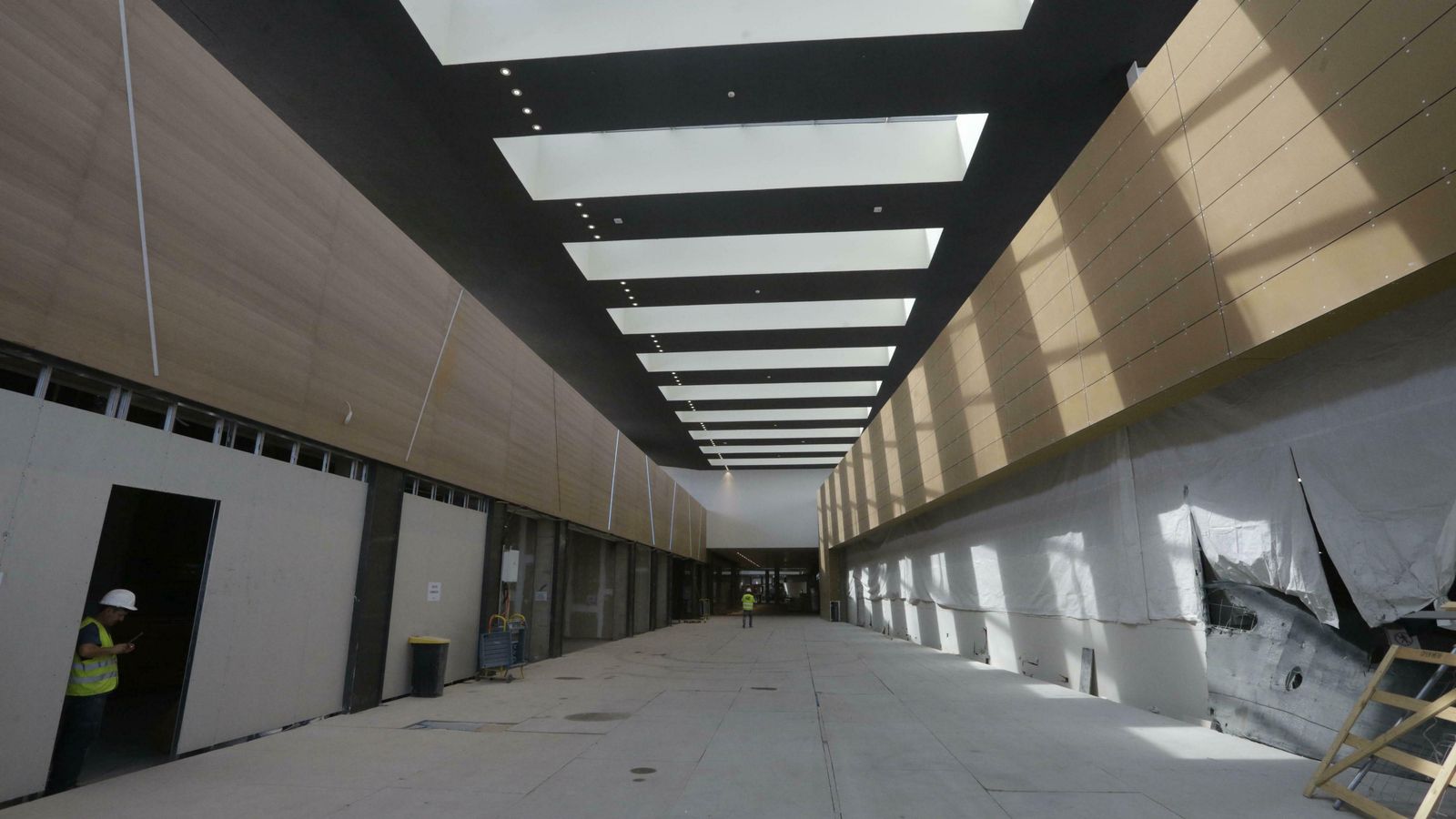 Luz y tonos madera, blanco y negro en los revestimientos interiores de los pasillos.