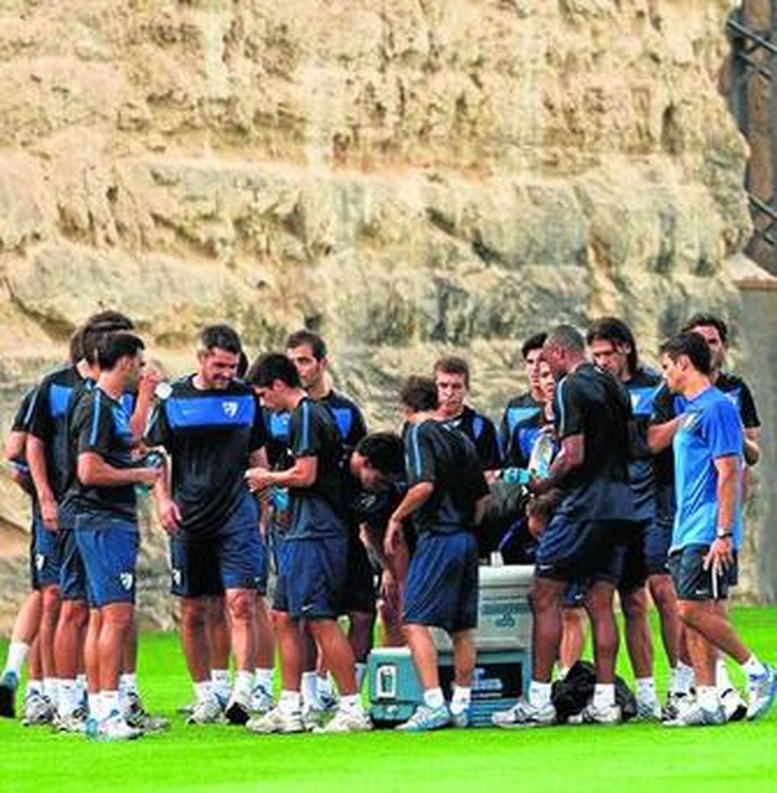 La plantilla se refresca en uno de los momentos de descanso del entrenamiento de ayer.
