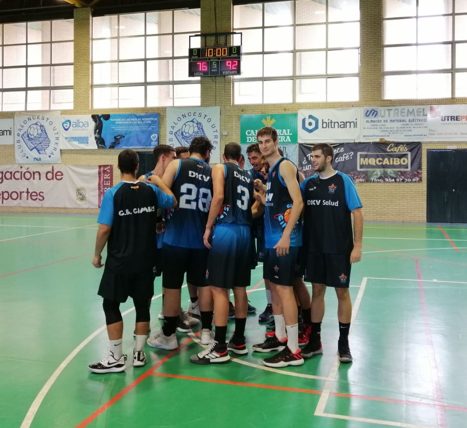 Los jugadores del DKV celebran el triunfo en Utrera con el marcador al fondo.