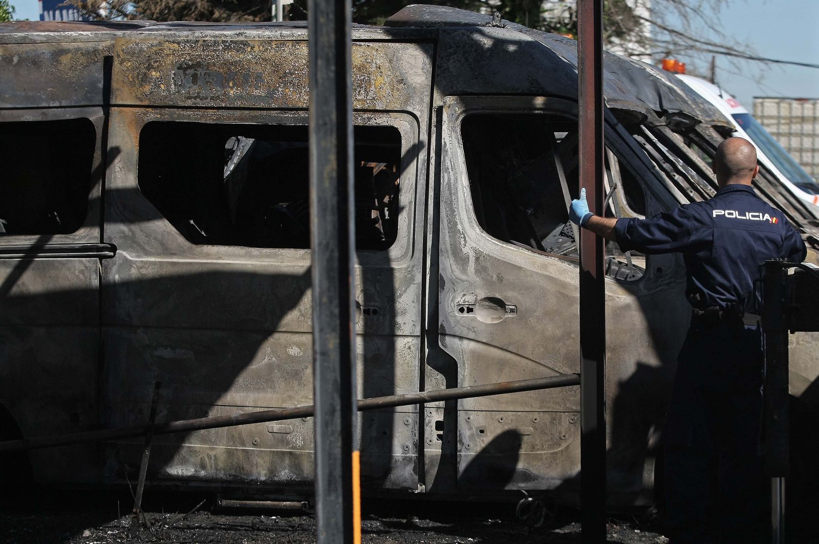 Un agente de la Policía Nacional, junto a la hilera de ambulancias calcinadas.