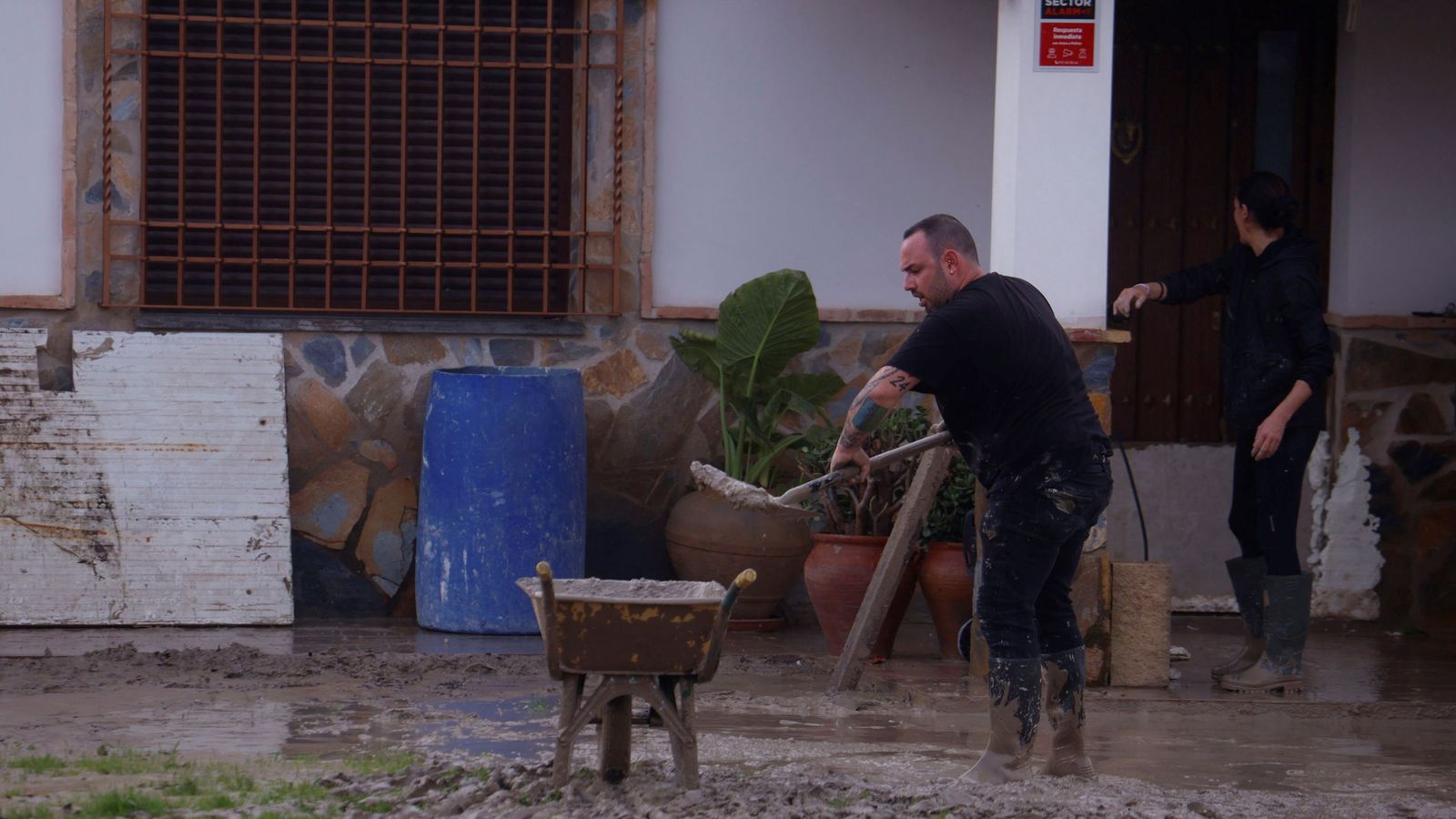 Vecinos limpian el barro en la urbanización Las Cigüeñas