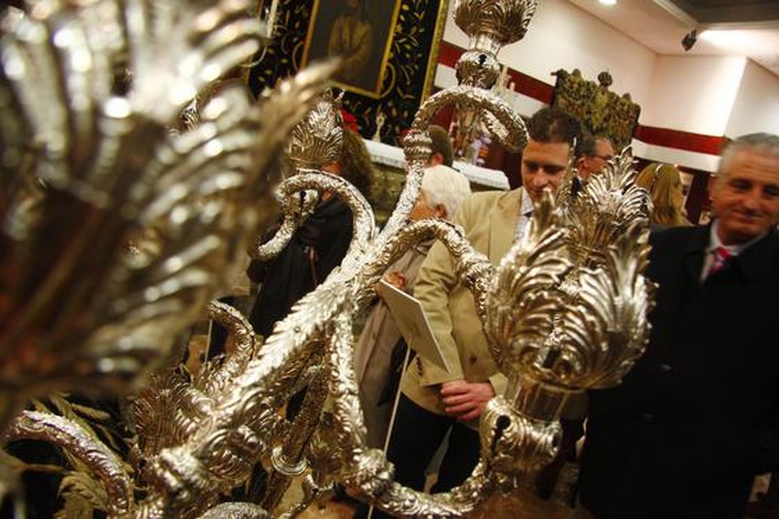 Los visitantes aprecian los objetos de la exposición "Tan lejos y tan cerca", de la Hermandad de la Amargura.

Foto: Belen Vargas