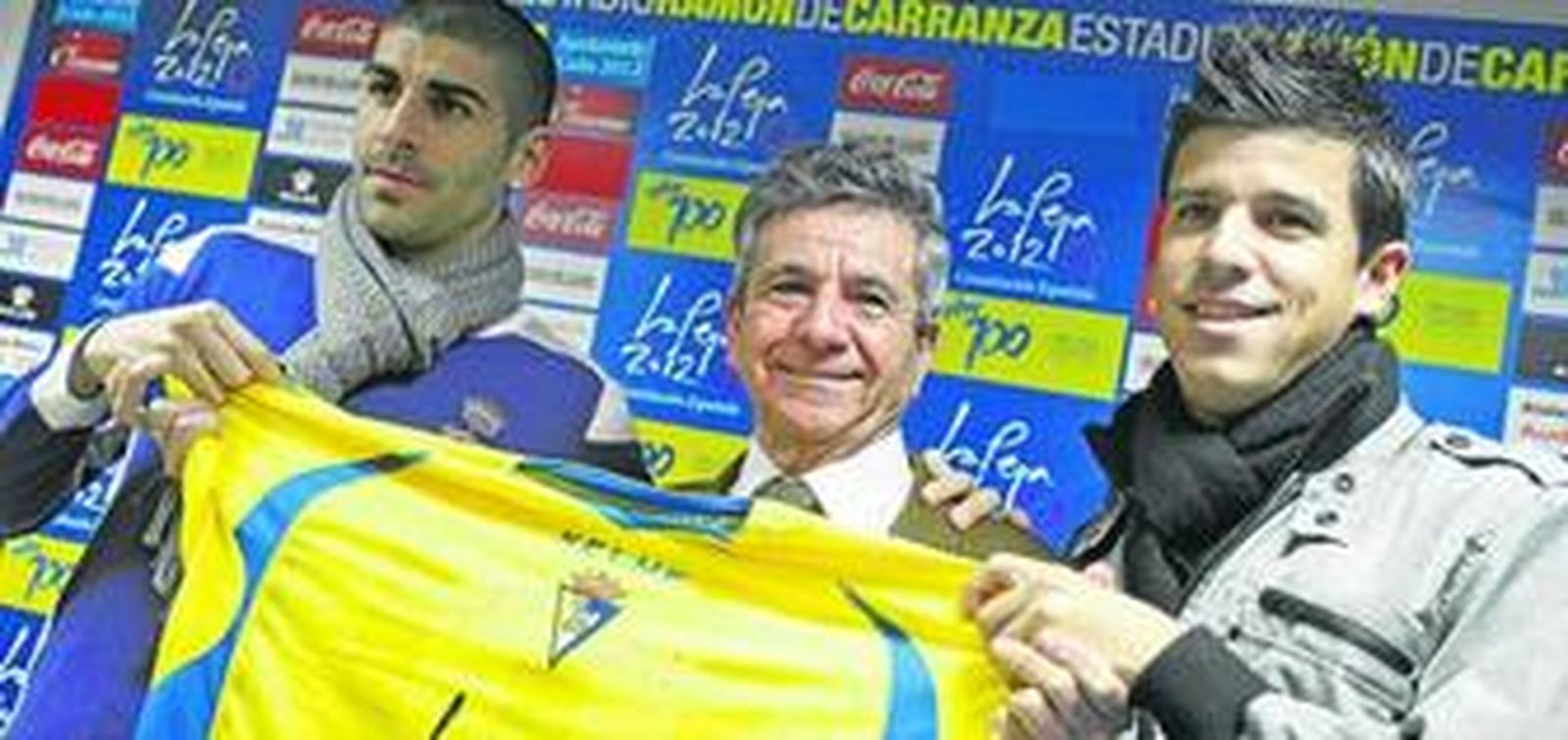 Antonio Moreno (i) y Juanse (d) aguantan una camiseta del Cádiz junto a Enrique Huguet durante la presentación de ayer en el estadio Carranza.
