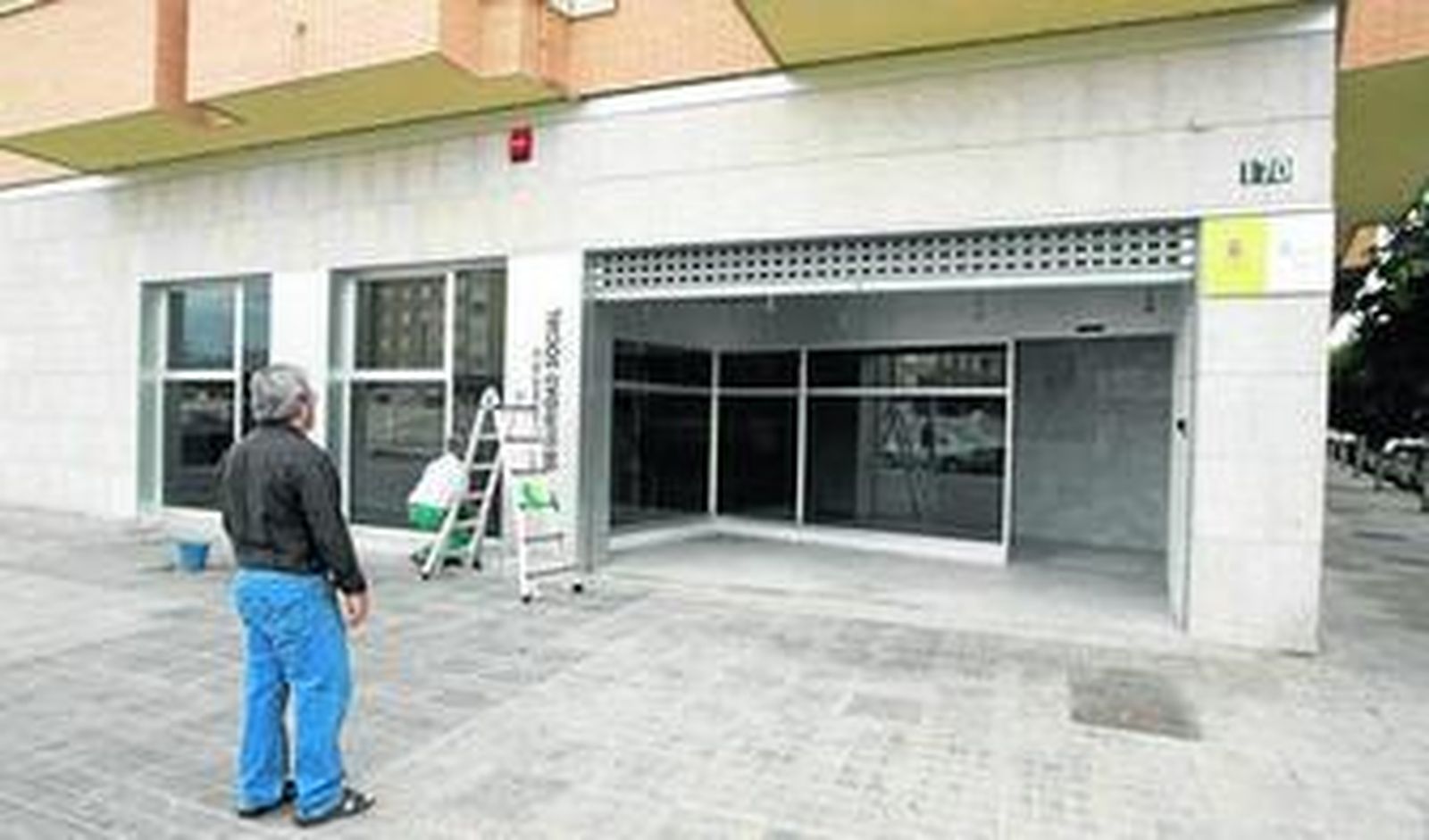 Un vecino de la zona observa cómo se ultiman los detalles del nuevo centro del INSS en Almería.