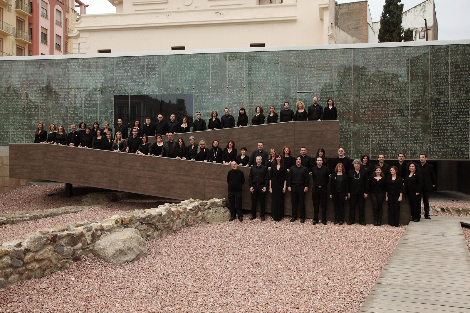 La Coral Cármina Nova, al completo, en formación junto al cen tro de interpretación del Teatro Romano.