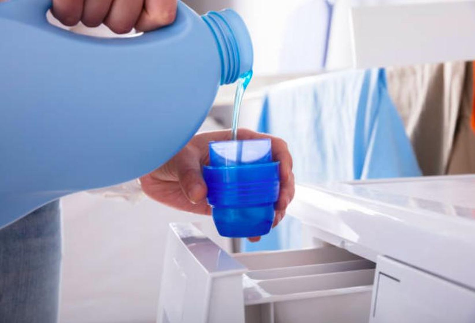 Momento de echar suavizante en el tapón para añadirlo a la lavadora