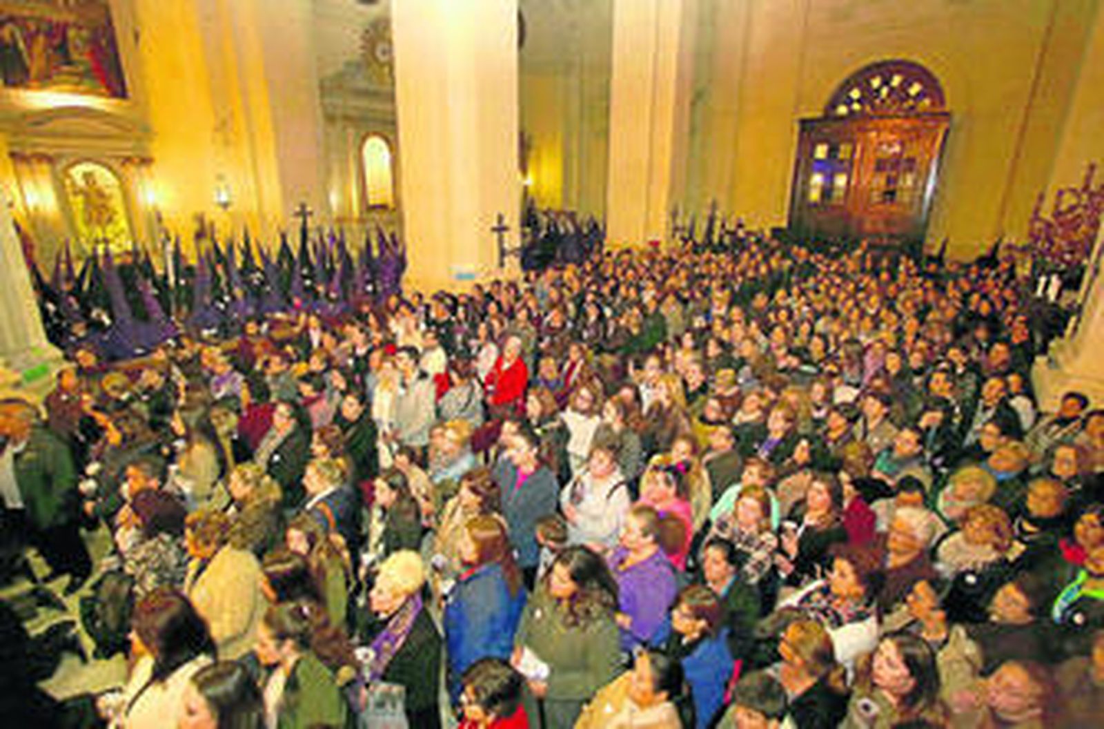 Cientos de personas toman parte en la estación de penitencia en el interior de la Iglesia Mayor antes de iniciarse la salida procesional.
