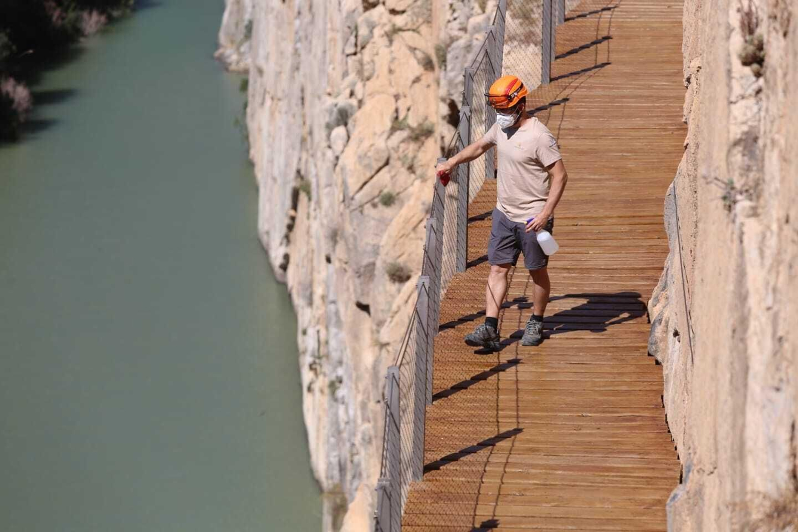 Un trabajador limpia las barandillas del Caminito del Rey