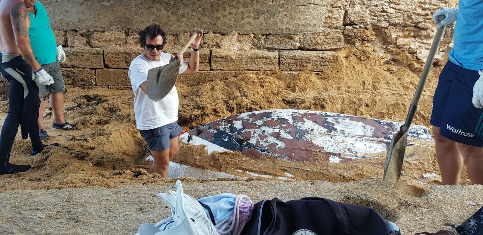 El alcalde, José María González Kichi, desentierra una de las embarcaciones encontradas.