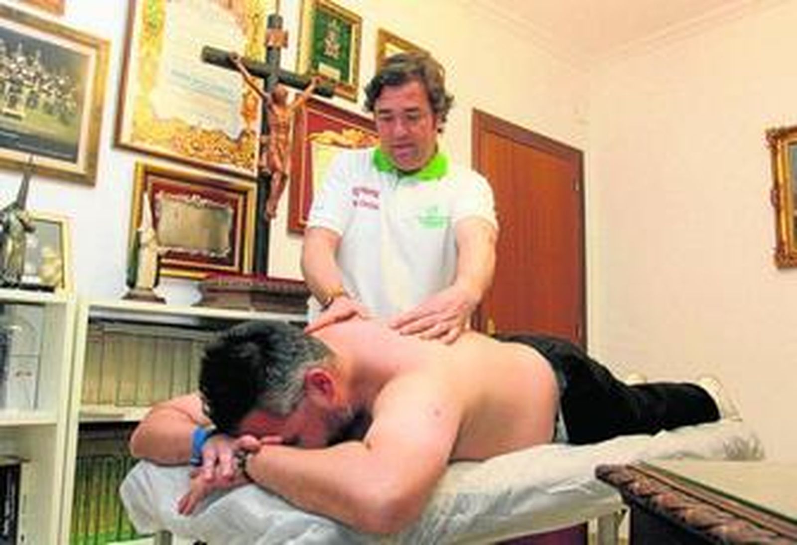 José Luis Borralo, ayer en la casa de la Hermandad de las Tres Caídas, atendiendo a uno de los costaleros.