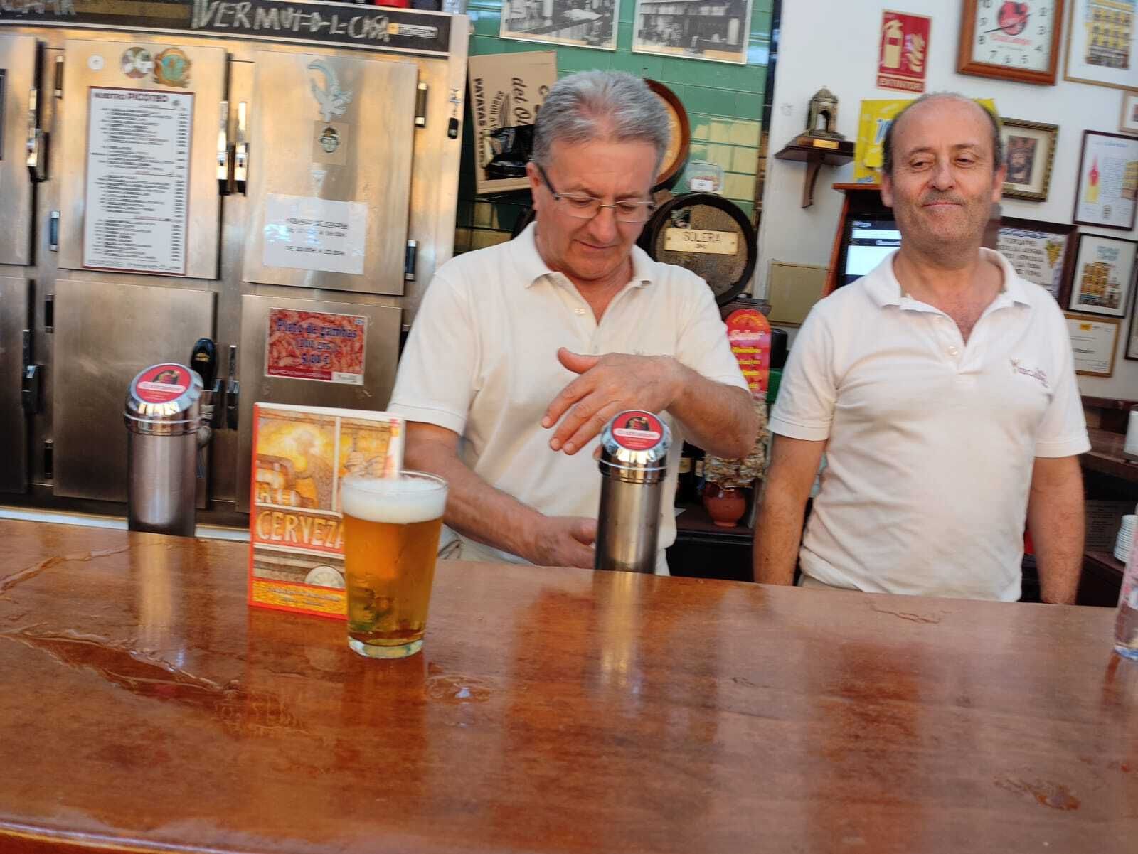 Antonio y Curro, camareros del Vizcaíno, junto a una caña y un ejemplar de Cuadernos.
