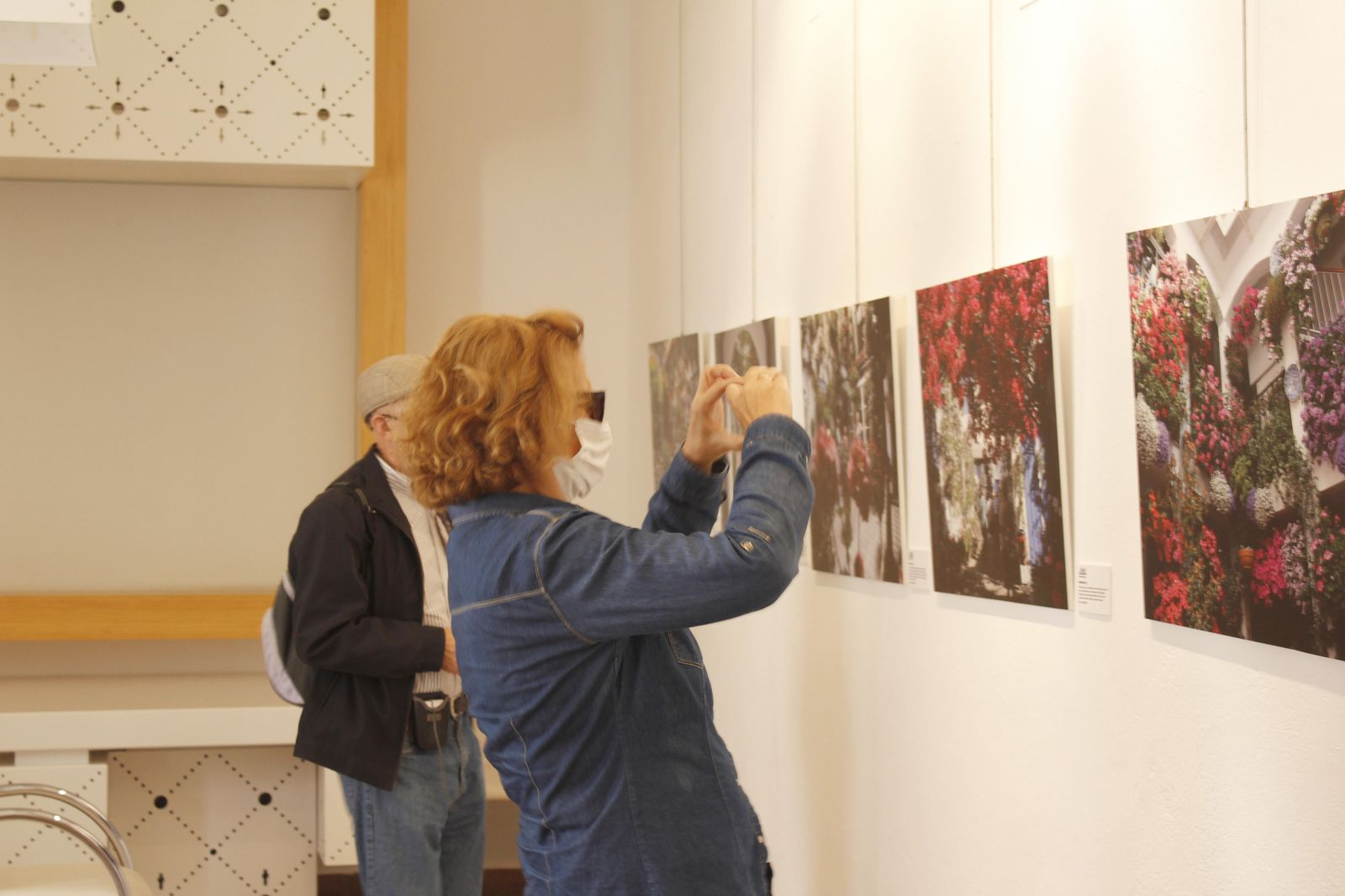 Una pareja visita la exposición en el Palacio de Viana.