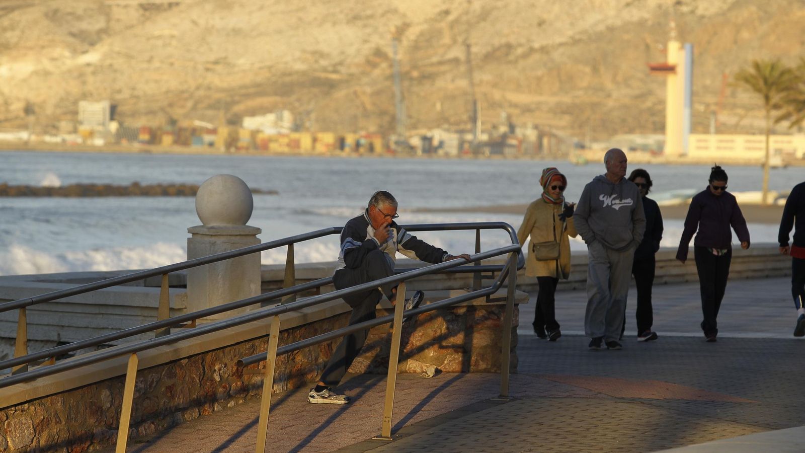 Un deportista veterano realiza estiramientos frente al Auditorio.