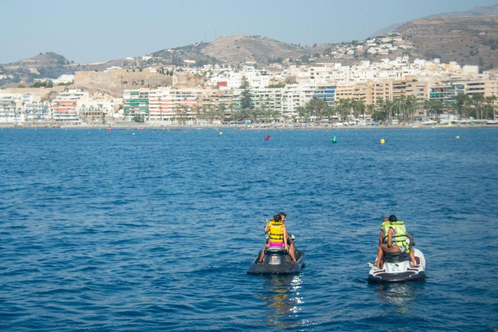 Varias personas disfrutan de una jornada de playa con las motos de agua