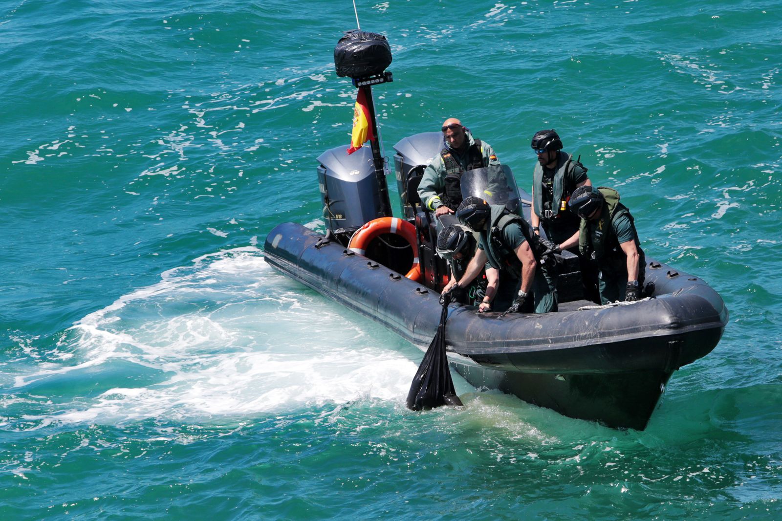 Miembros del Servicio Marítimo de la Guardia Civil rescatan el bulto que flotaba en el mar.