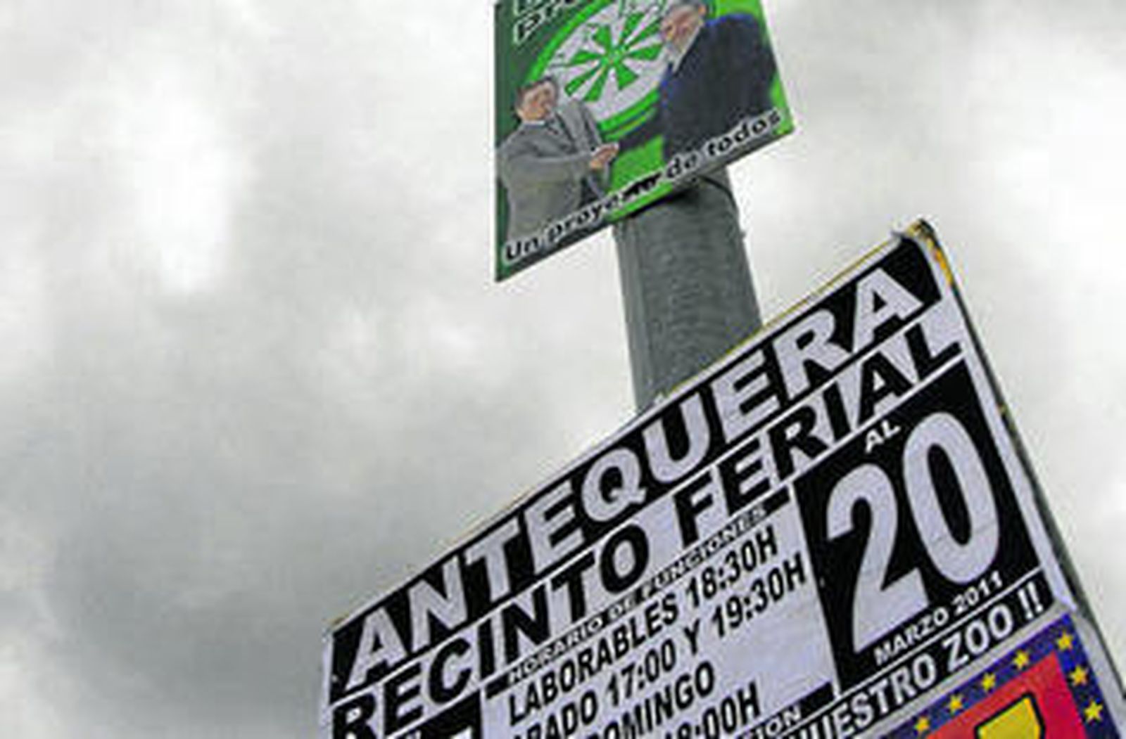 Un cartel electoral y un anuncio de un circo en una farola, ayer.