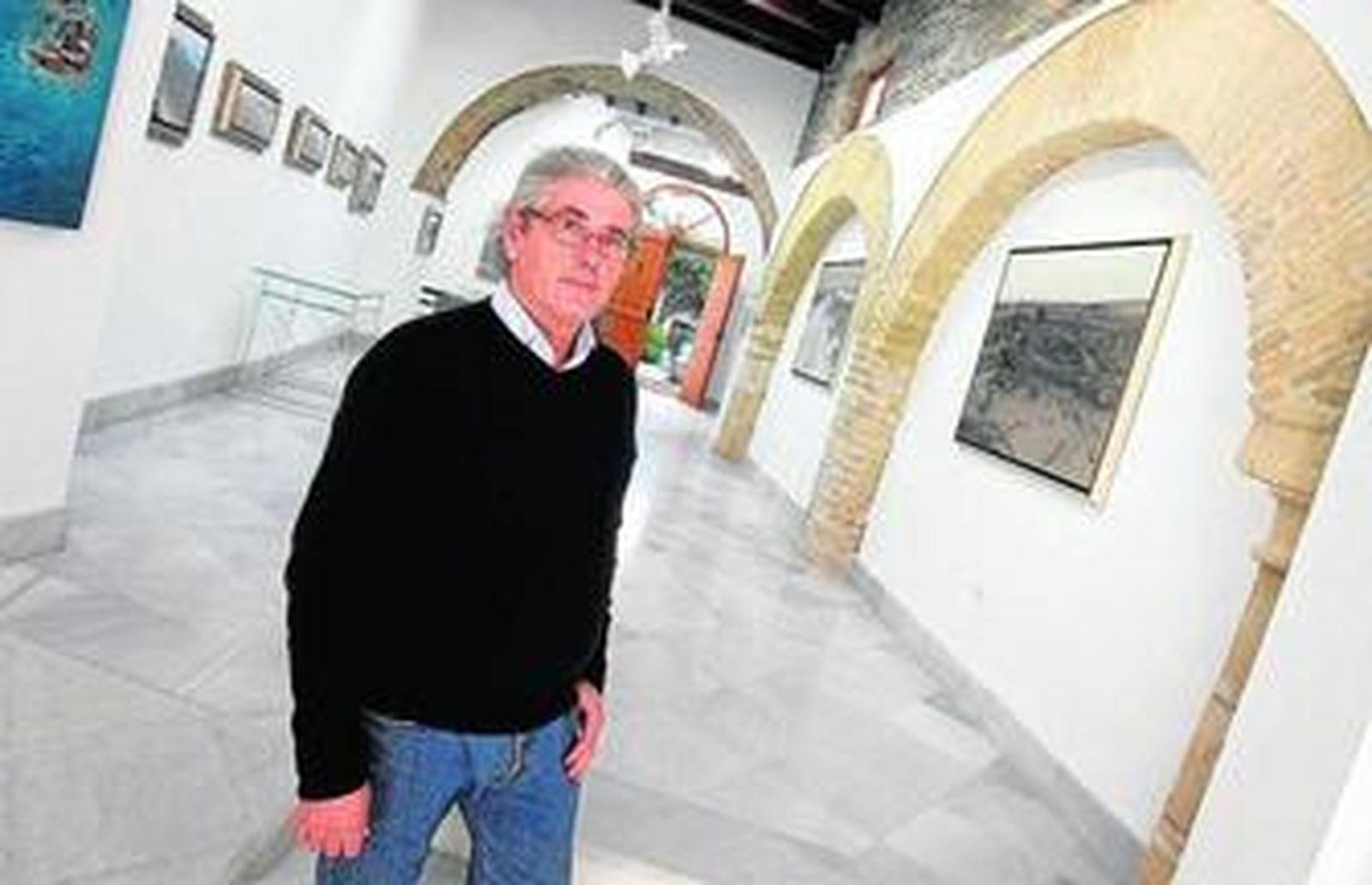 José Basto posa junto a algunas de sus obras en su estudio-galería, ayer.