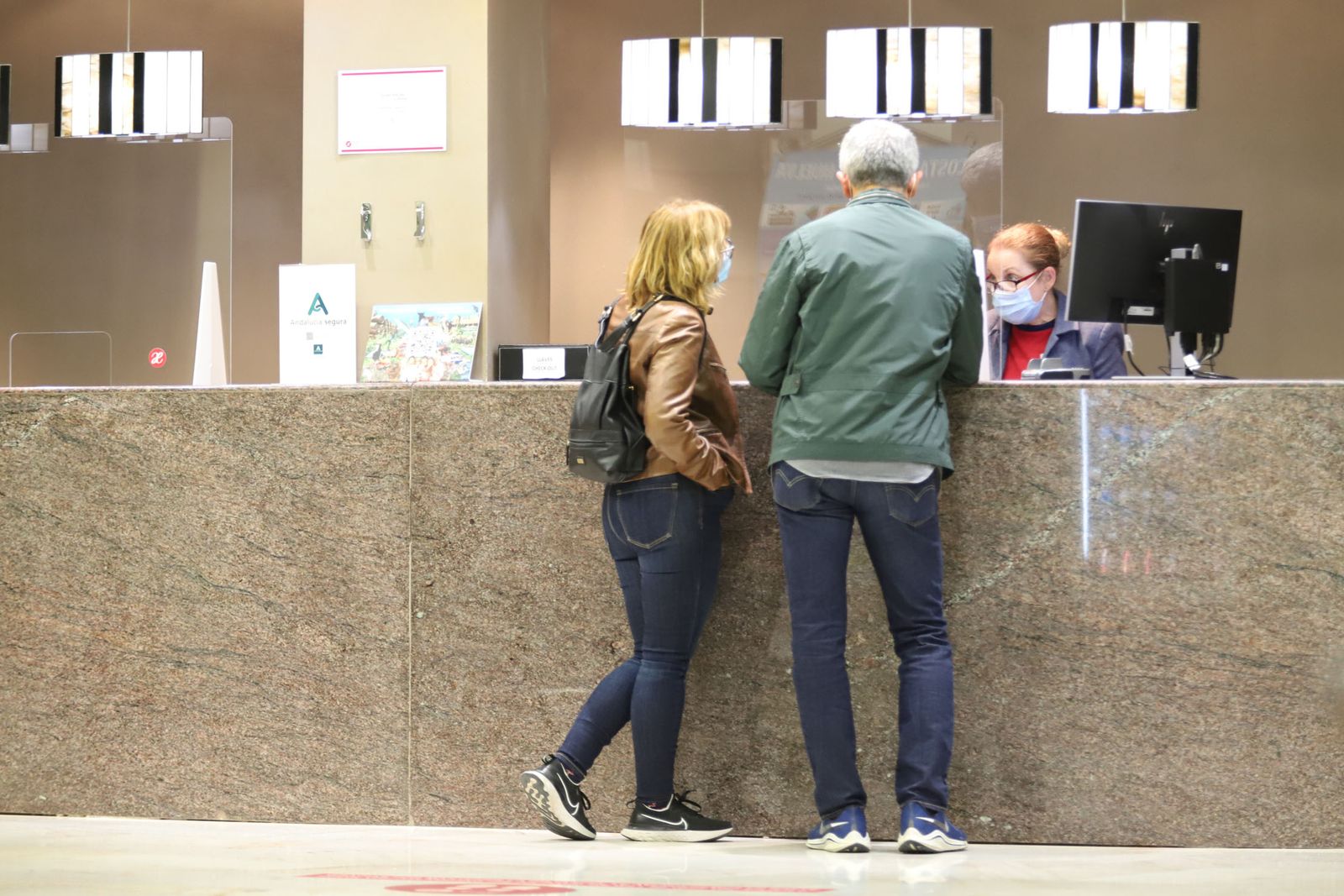Una pareja en el mostrador de un hotel de la capital onubense.