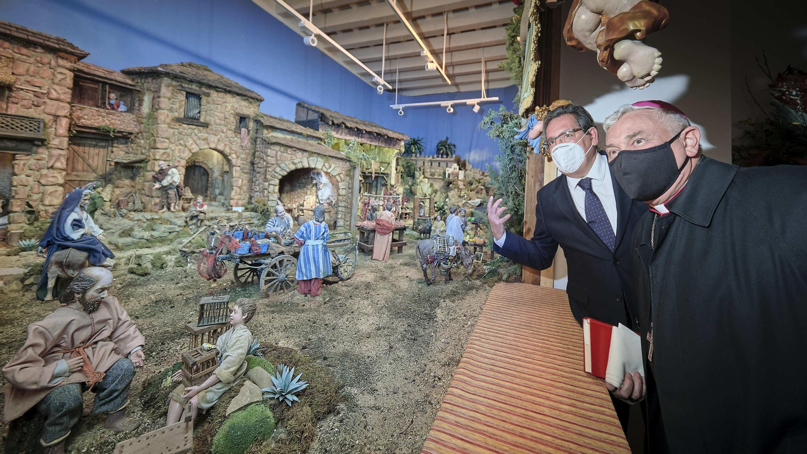 Monseñor Zornoza en primer término y Antonio Pulido observan el Belén de la Fundación Cajasol.