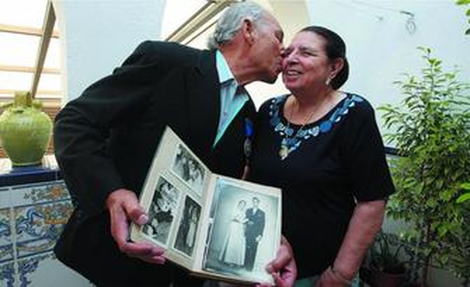 El matrimonio Suárez-Antúnez posando ayer en el patio de su casa con el álbum de fotos familiar.