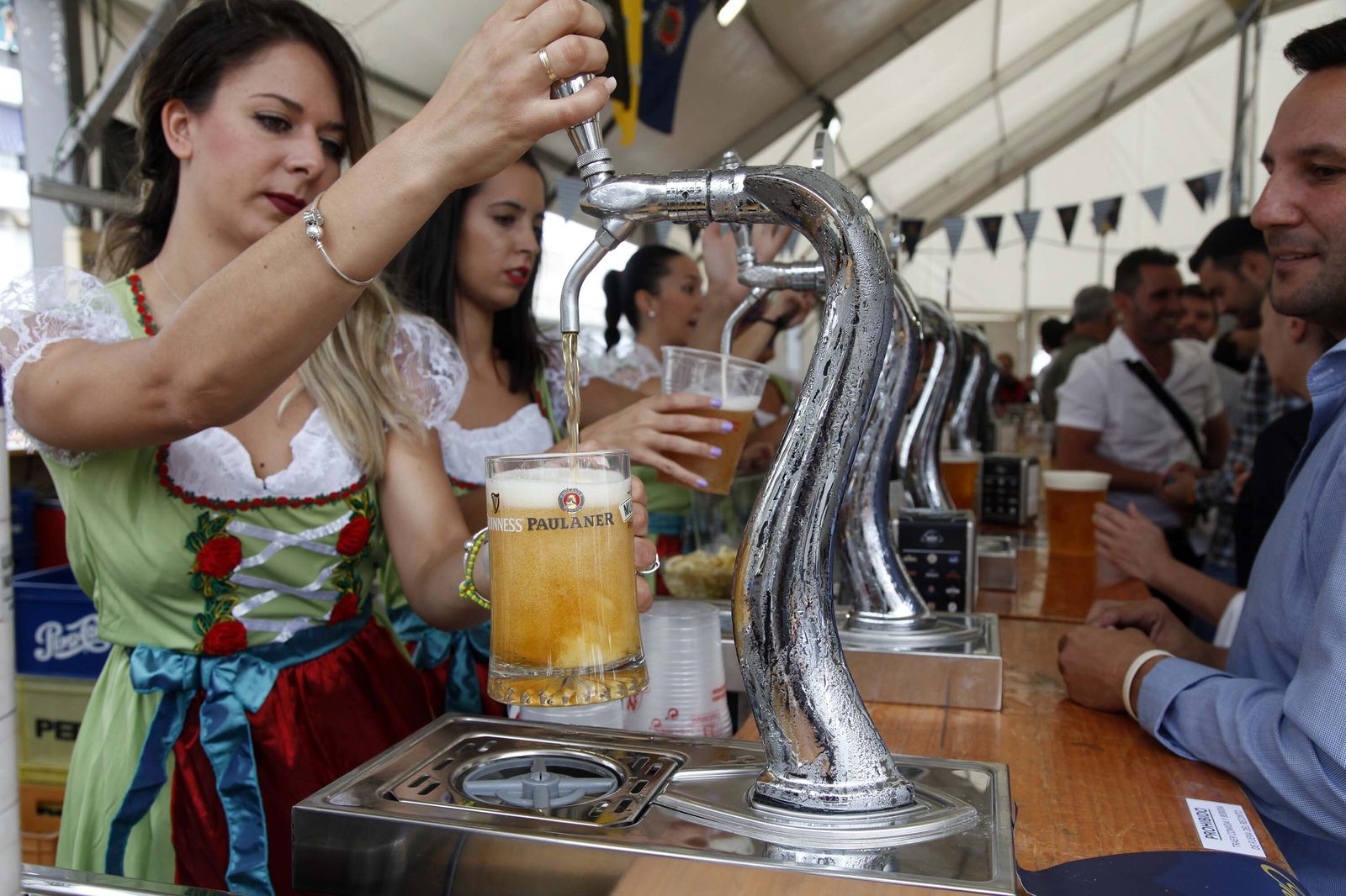 Camareras ponen cervezas en una feria.