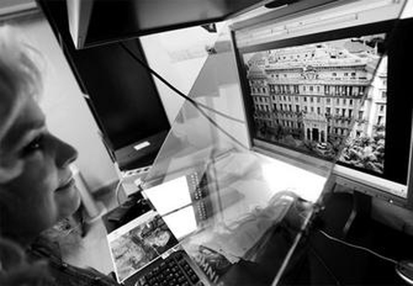 Una de las operarias de Gestión Minera trabaja en el ordenador sobre la fachada principal del Palacio Miramar.