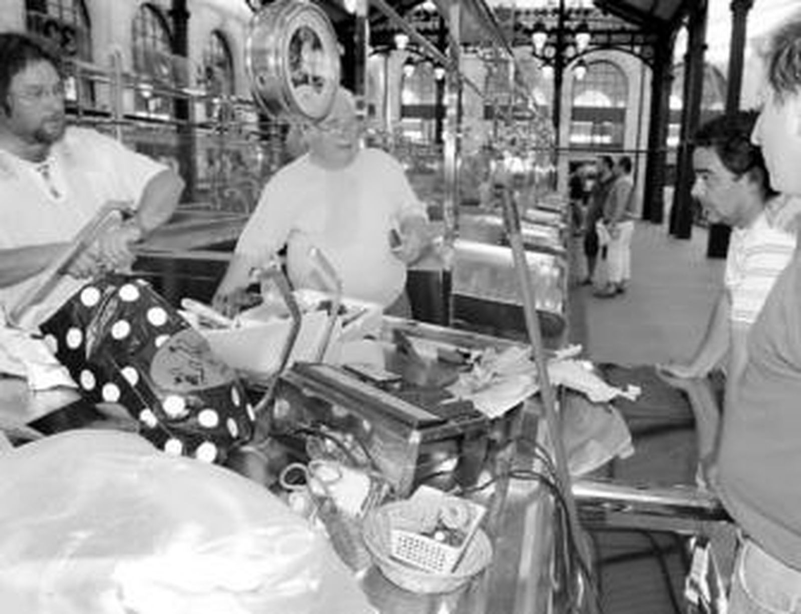 Pescaderos conversan ayer en la plaza ante un mostrador repleto de objetos: cuchillos, tijeras, cepillos...