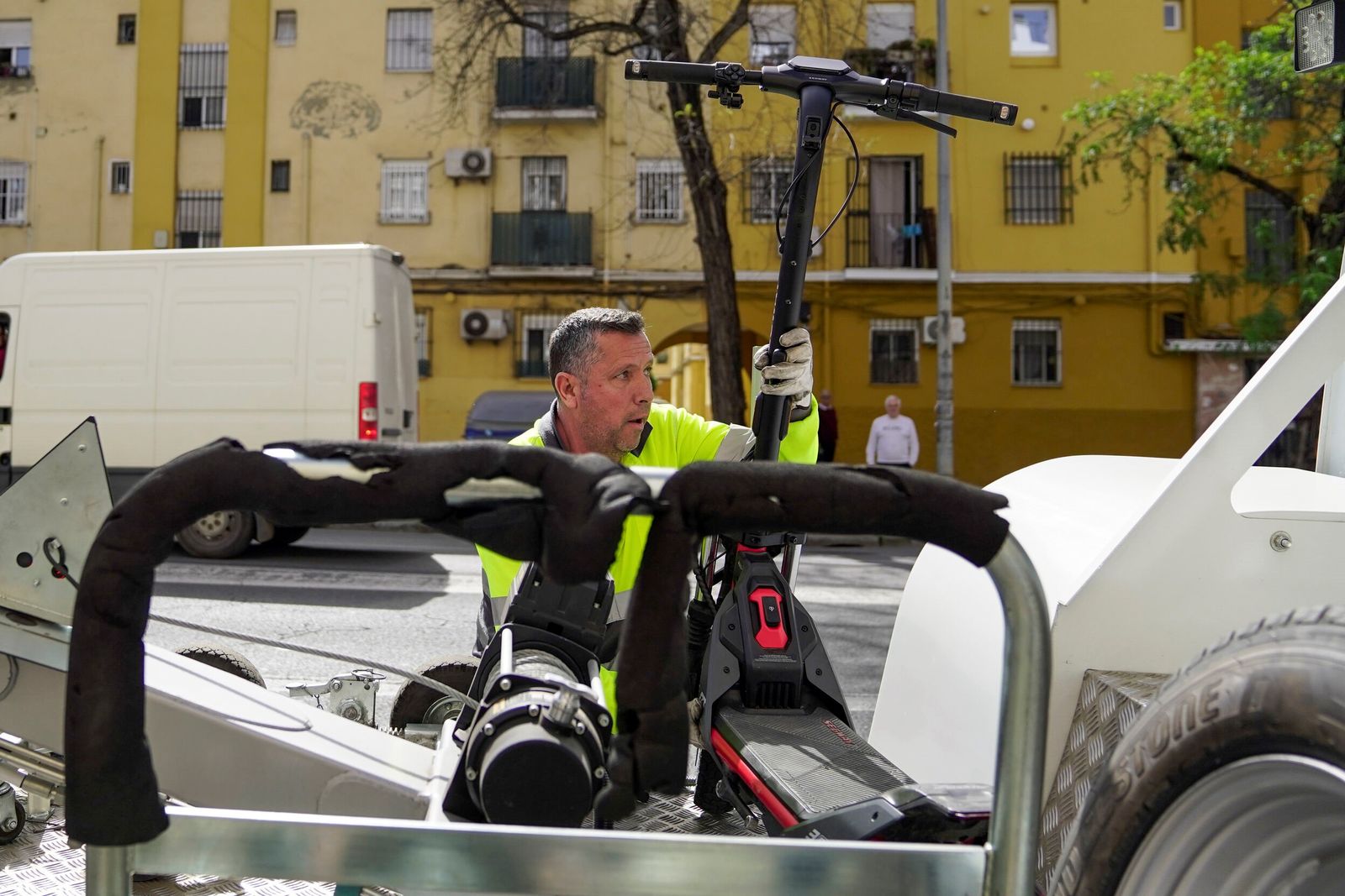 Un operario sube el patinete a la grúa.