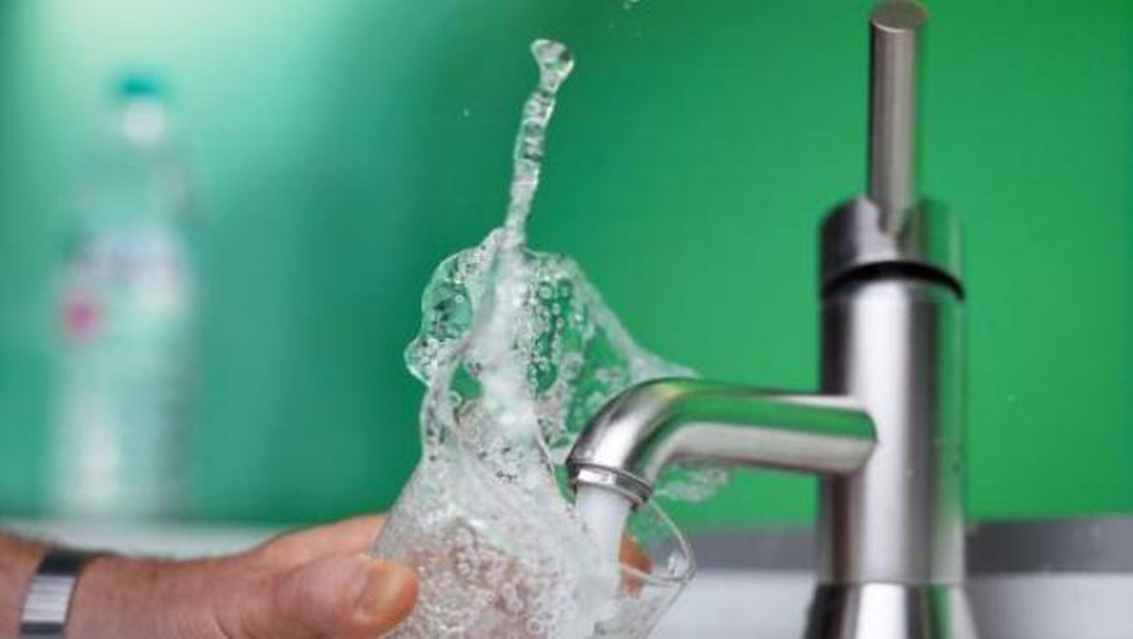 Un ciudadano llena un vaso con el agua que sale de un grifo