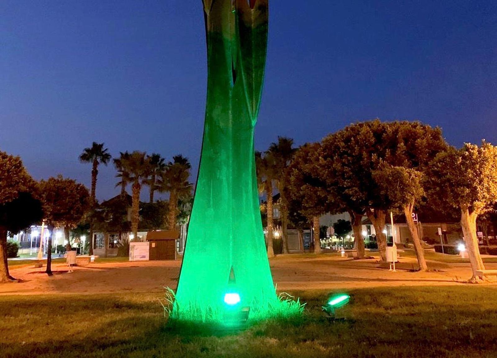 La escultura de la Plaza Manuel Camacho iluminada de verde.