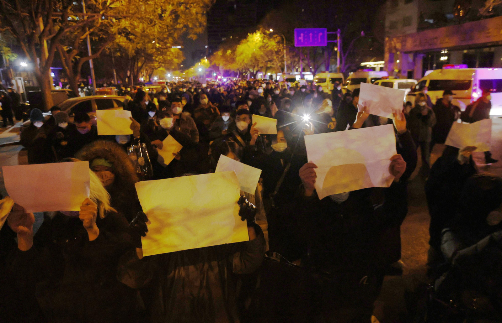 Manifestantes marchan con folios en blanco por las calles de Pekín.