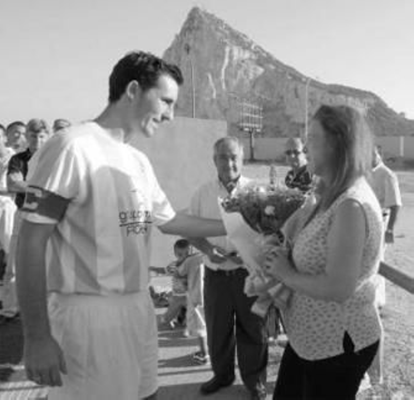 Julián entrega un ramo de flores a la hija del homenajeado.