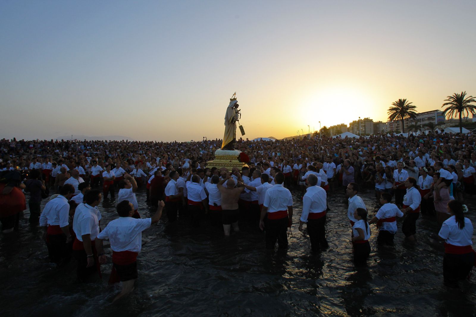 La Virgen del Carmen de El Palo, ante cientos de malagueños en el momento de su embarque.