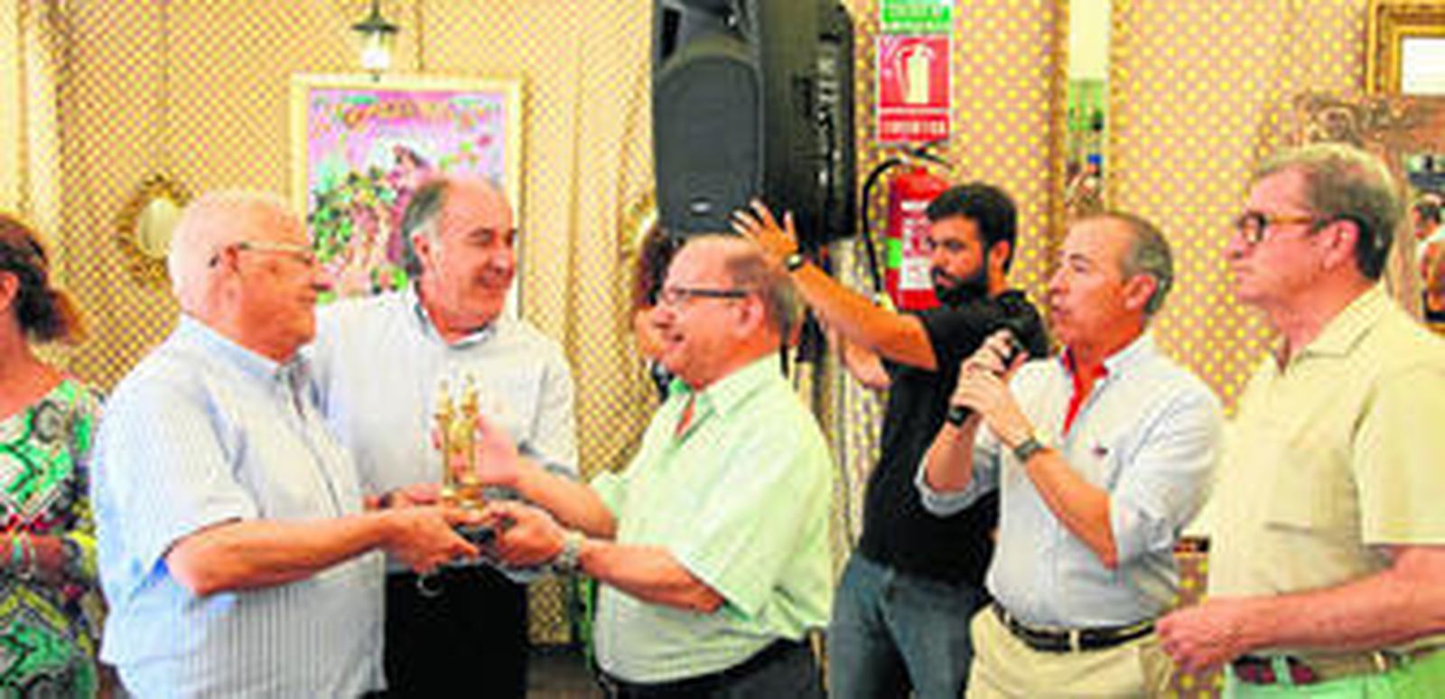 El alcalde y el presidente de Farolillo entregan el reconocimiento al casetero José Luis Ramírez.