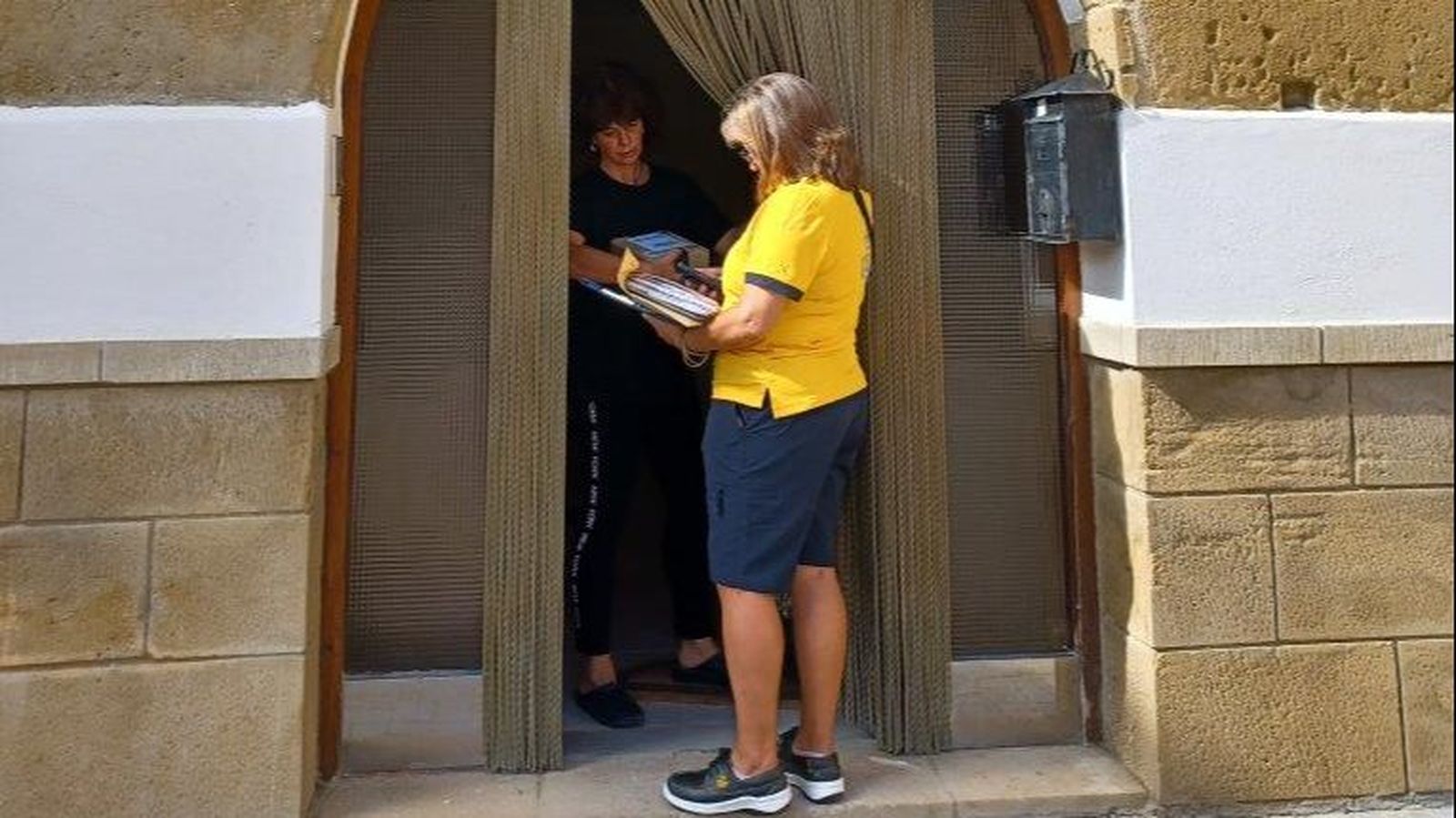 Una cartera de Correos entrega cartas en un pueblo de Granada
