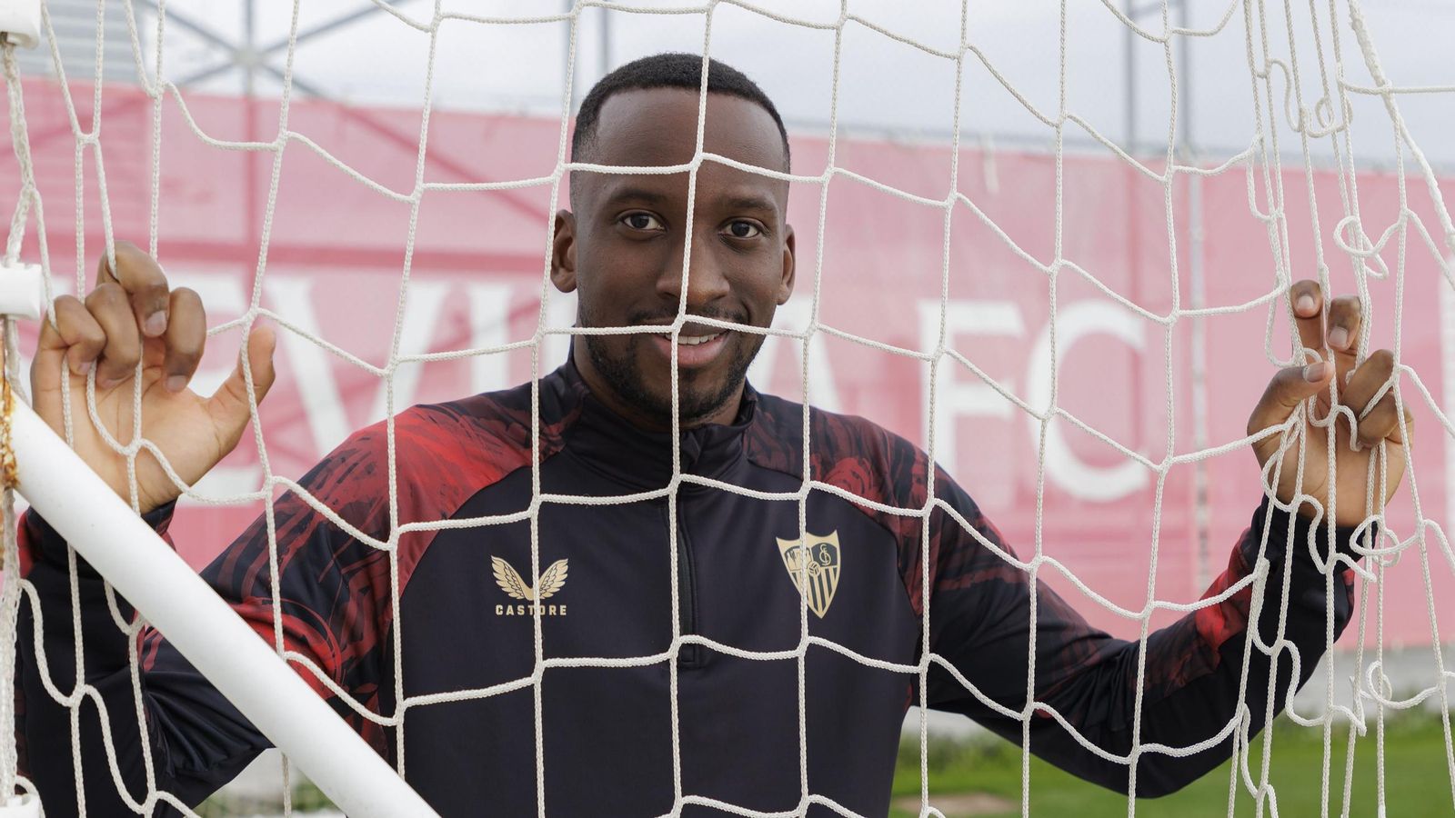 Dodi Lukébakio agarra las redes de una de las porterías de la ciudad deportiva.