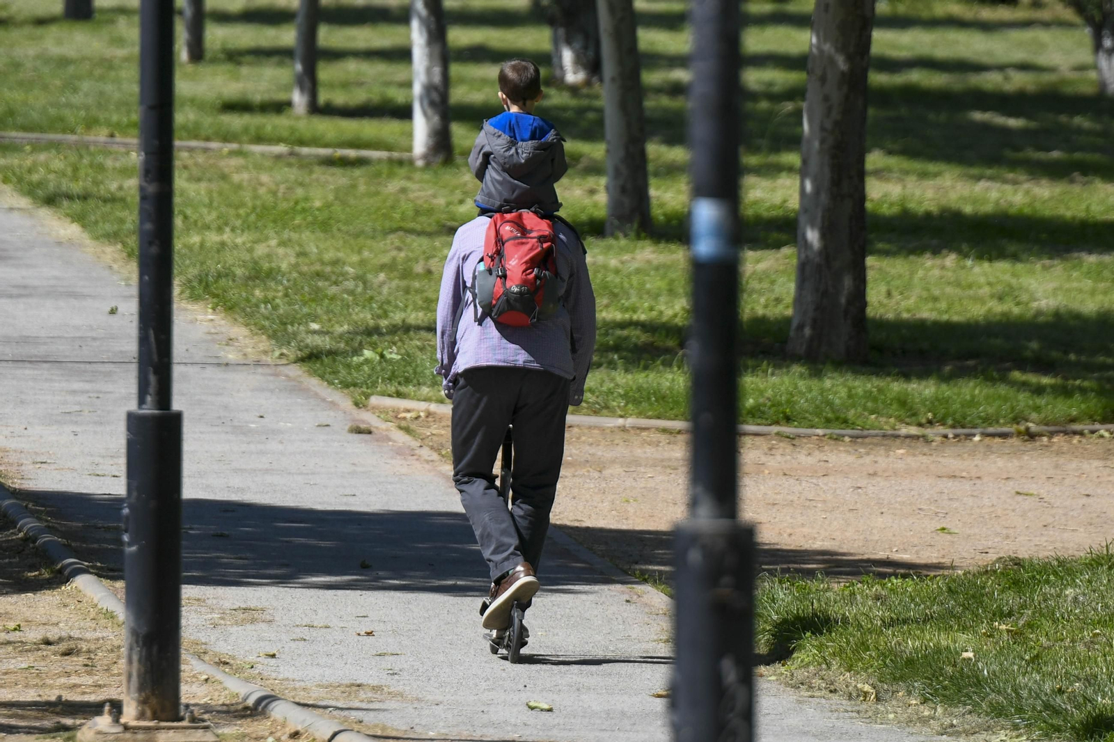 Un padre camina con su hijo por un parque