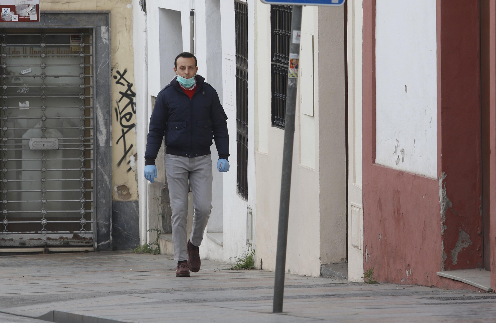 Un señor, ataviado con guantes y mascarilla.